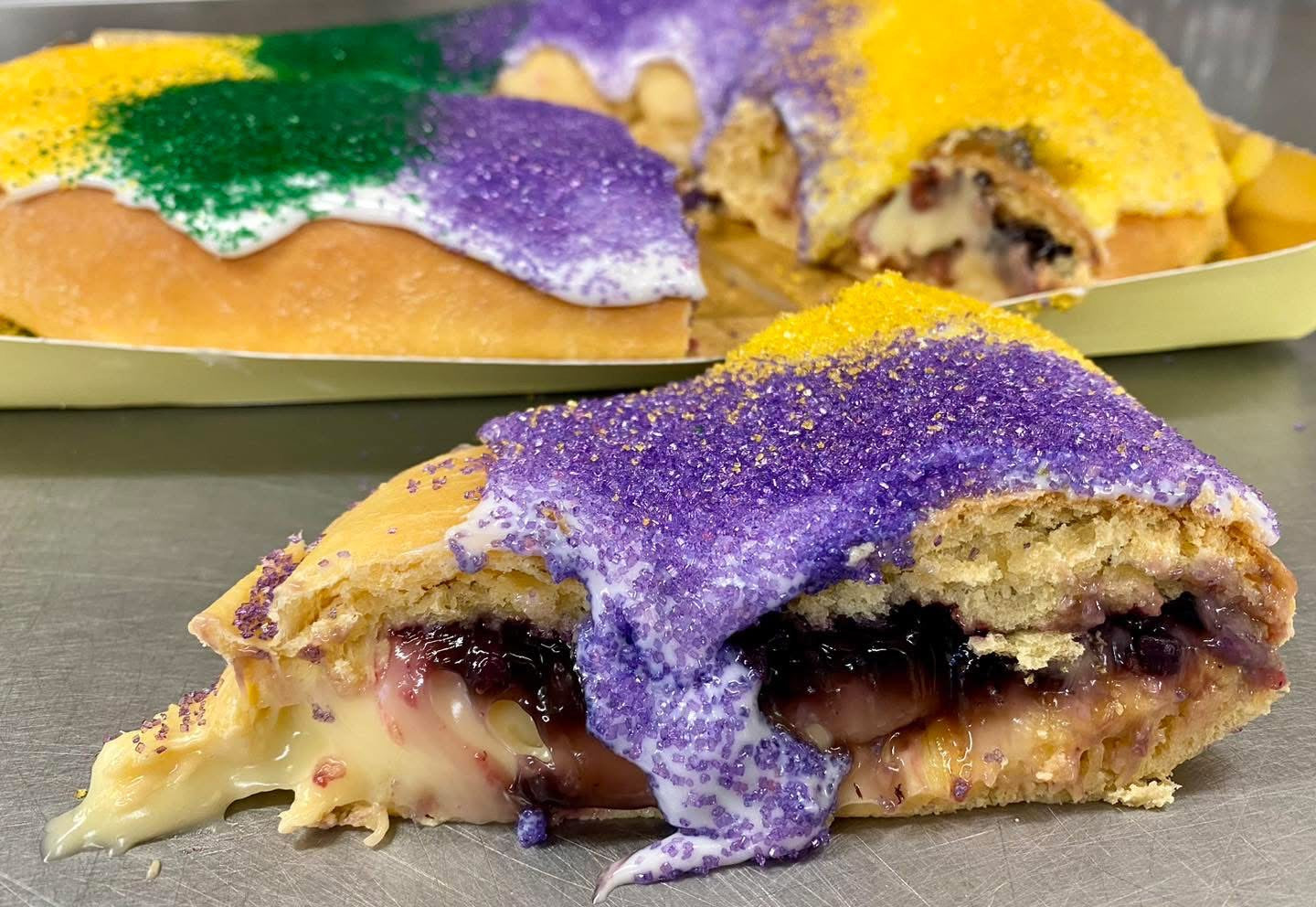 Blueberry and cream cheese king cake with classic icing and festive sugar on soft dough