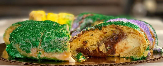 Cinnamon and cream cheese king cake with classic icing and festive sugar on soft dough